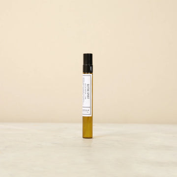 Small perfume bottle with a white label on a beige background