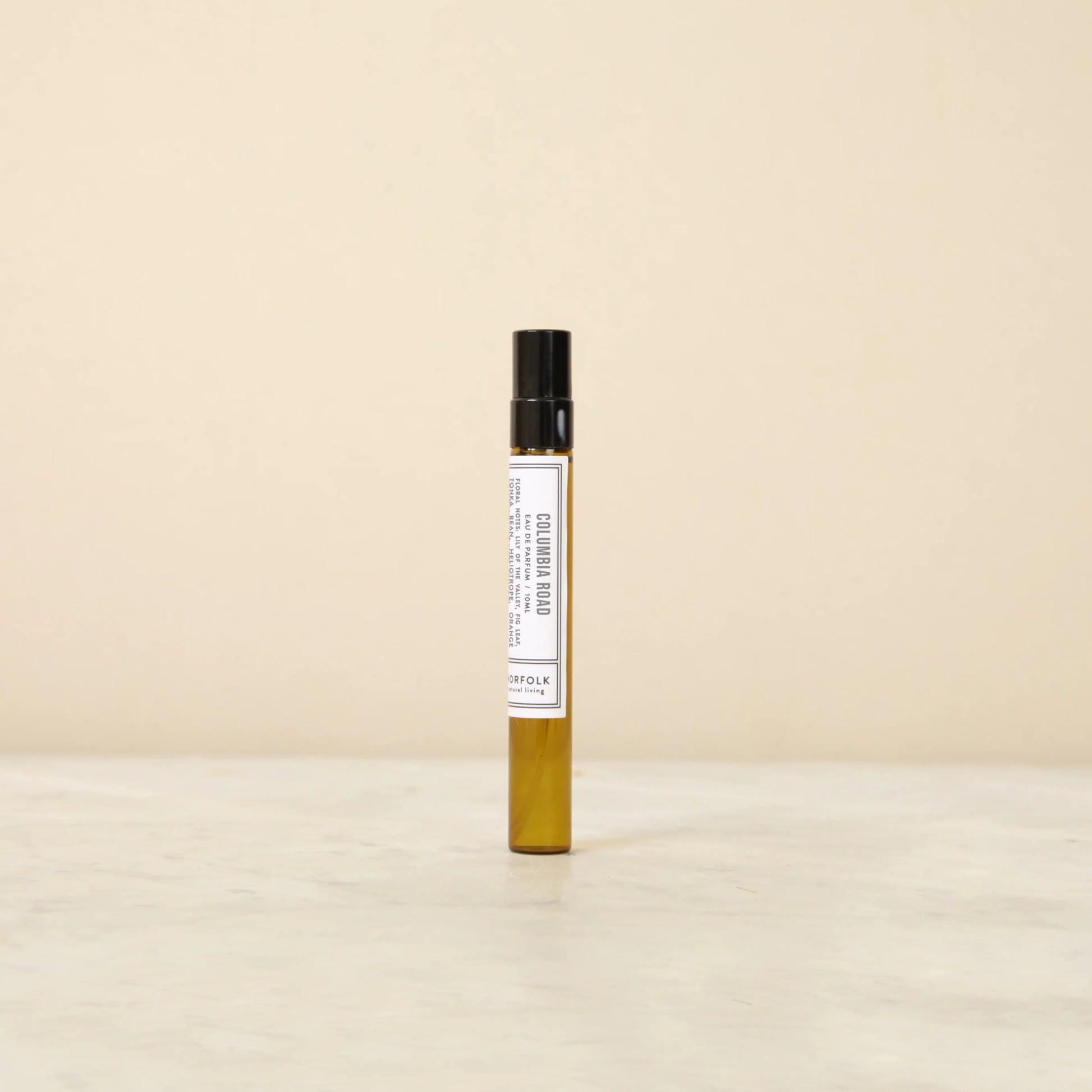 Small perfume bottle with a label on a beige background