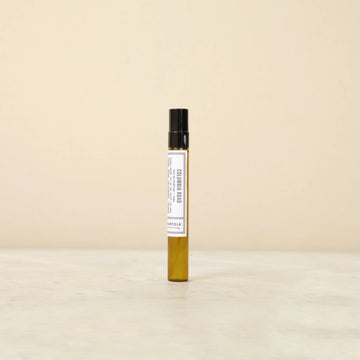 Small perfume bottle with a label on a beige background