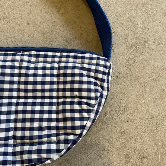 Navy and white checkered fabric on a beige surface