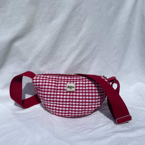 Red and white checkered waist bag with red strap on a white background