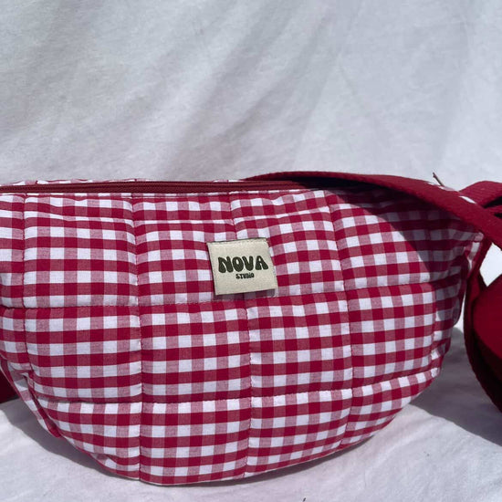Red and white checkered bag with 'Nova' label on a light gray background