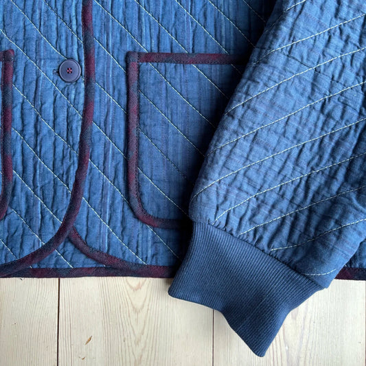 a sleeve on a blue jacket with a quilted detail 