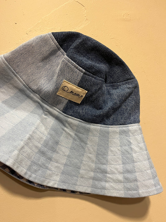 Patch denim bucket hat with large brim on a beige background