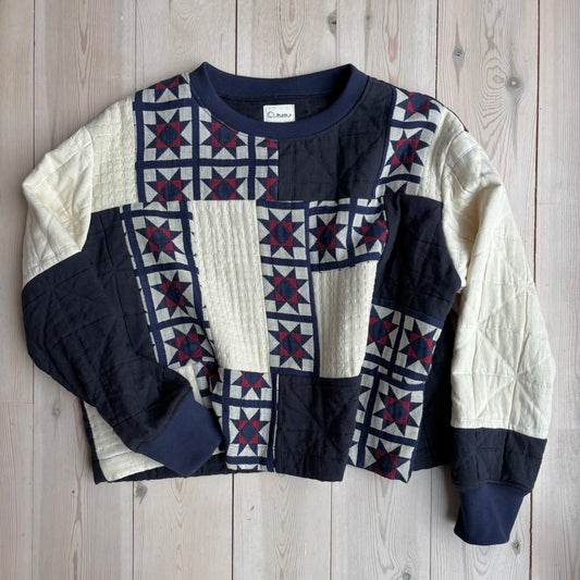A quilted patchwork sweater on a wooden background 