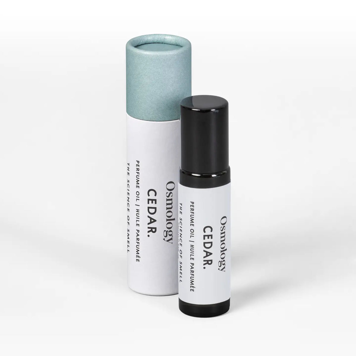 A small cylindrical roll-on bottle and its matching paper tube packaging, both labeled 'Osmology CEDAR: resin oil blend formula', on a clean white background.