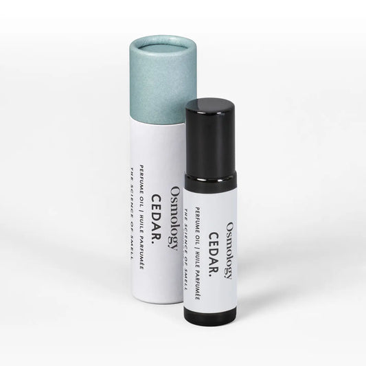 A small cylindrical roll-on bottle and its matching paper tube packaging, both labeled 'Osmology CEDAR: resin oil blend formula', on a clean white background.