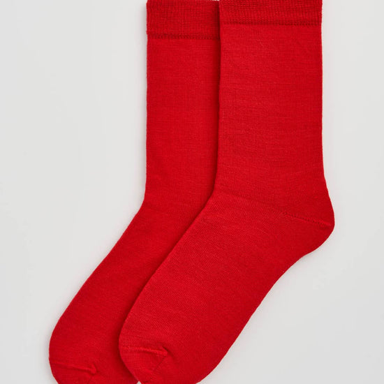 Pair of red socks on a light gray background