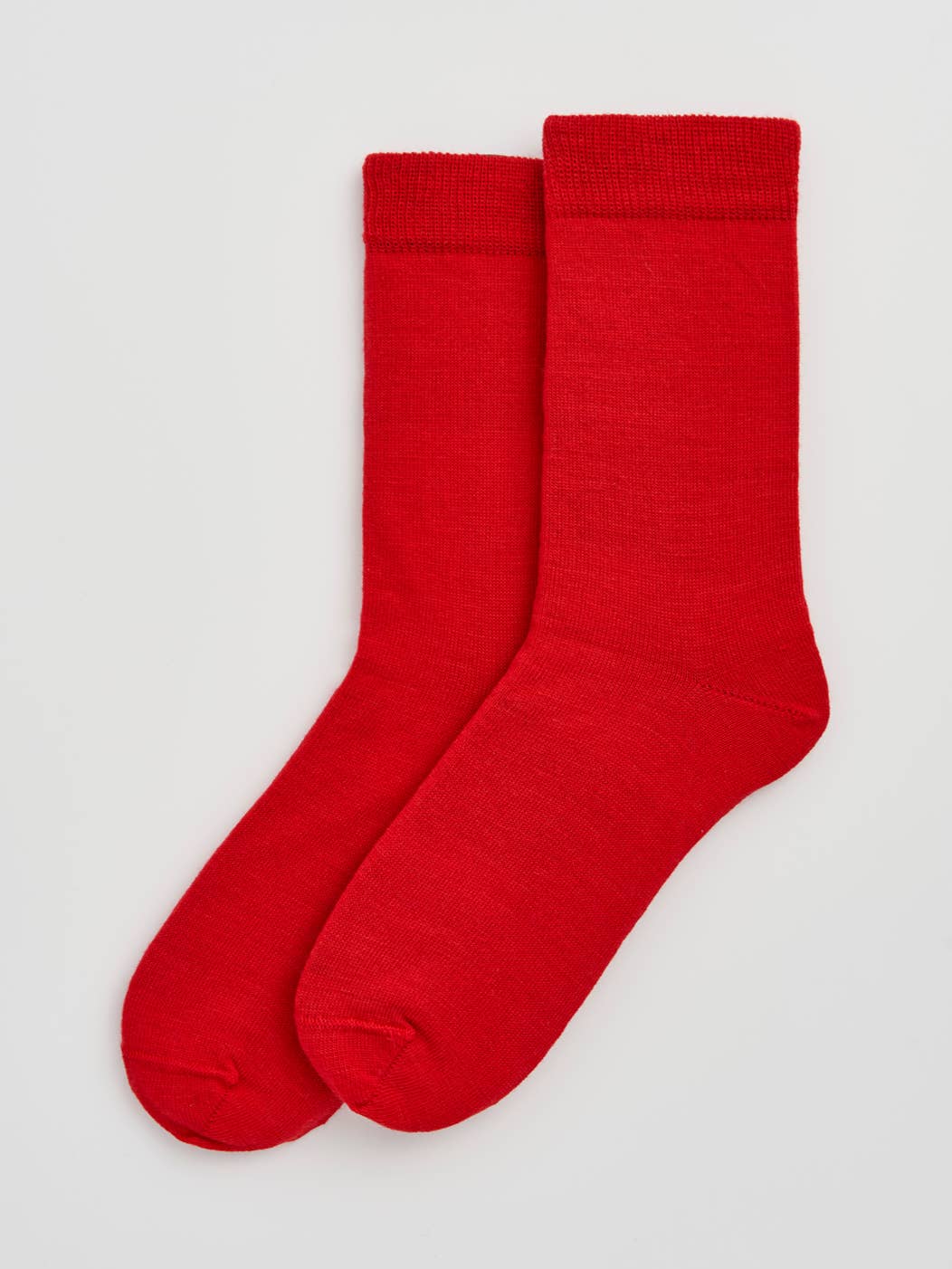 Pair of red socks on a light gray background