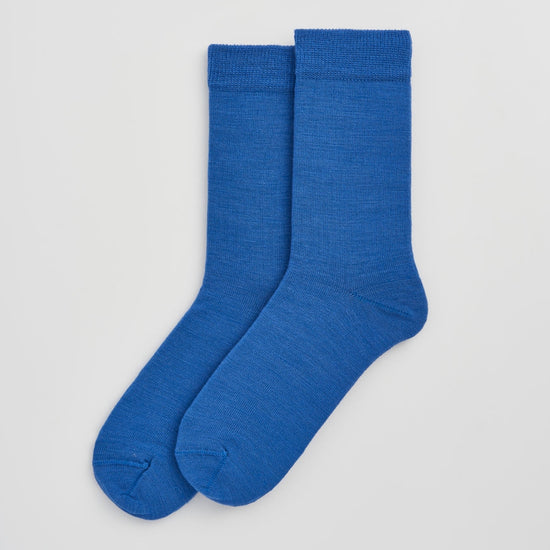 Pair of blue socks on a light gray background
