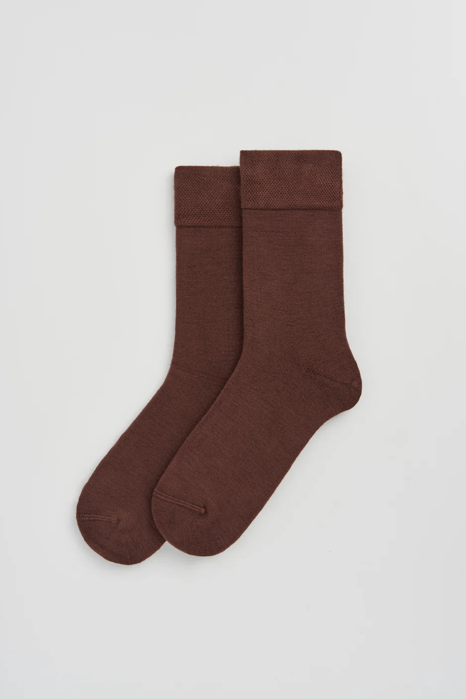 Pair of brown socks on a light grey background
