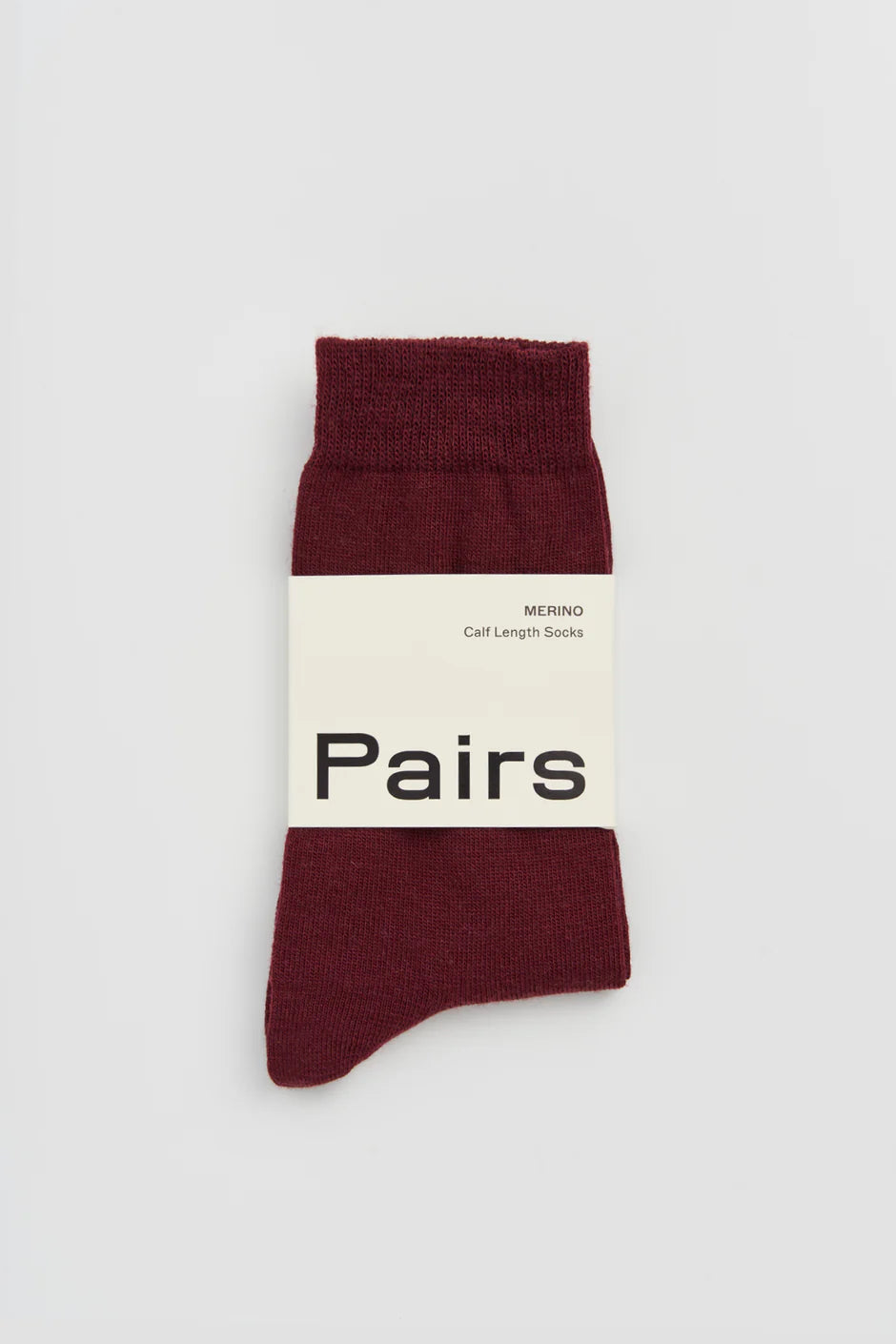 Dark plum sock with a white label on a light grey background