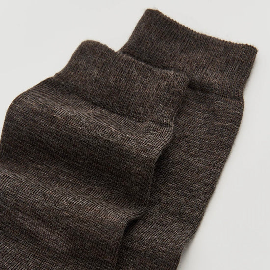Pair of dark gray socks on a light gray background
