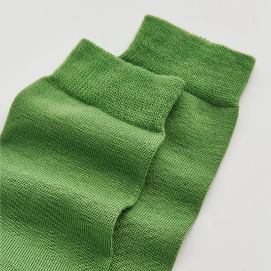 Green knitted socks on a white background