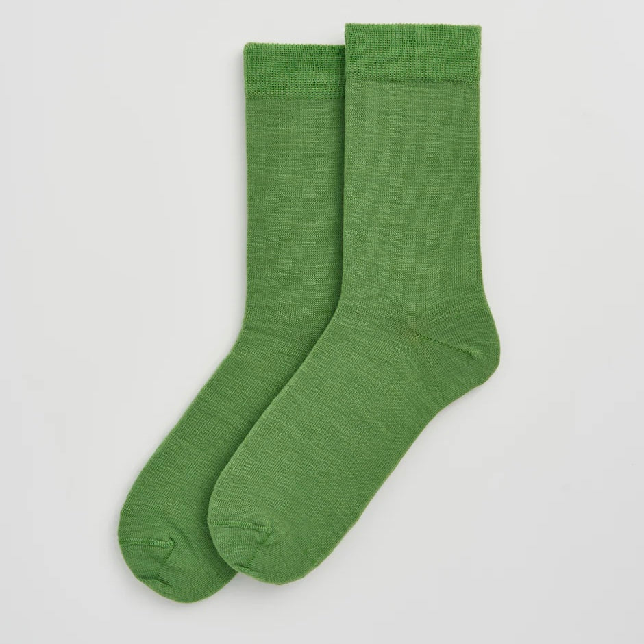 Pair of green socks on a light grey background