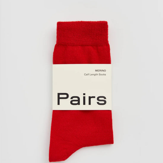 Red sock with a white label on a light grey background