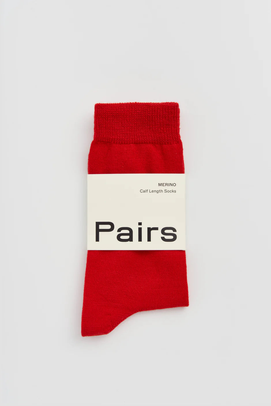 Red sock with a white label on a light grey background