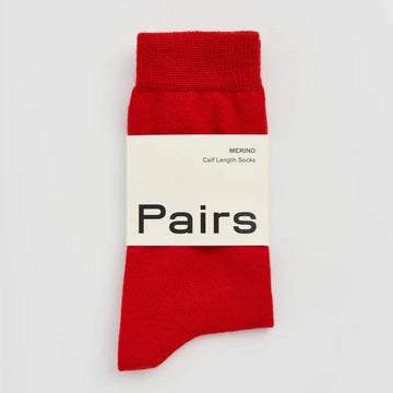Red sock with a white label on a light grey background