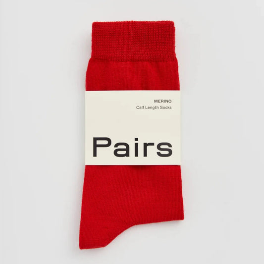 Red sock with a white label on a light grey background