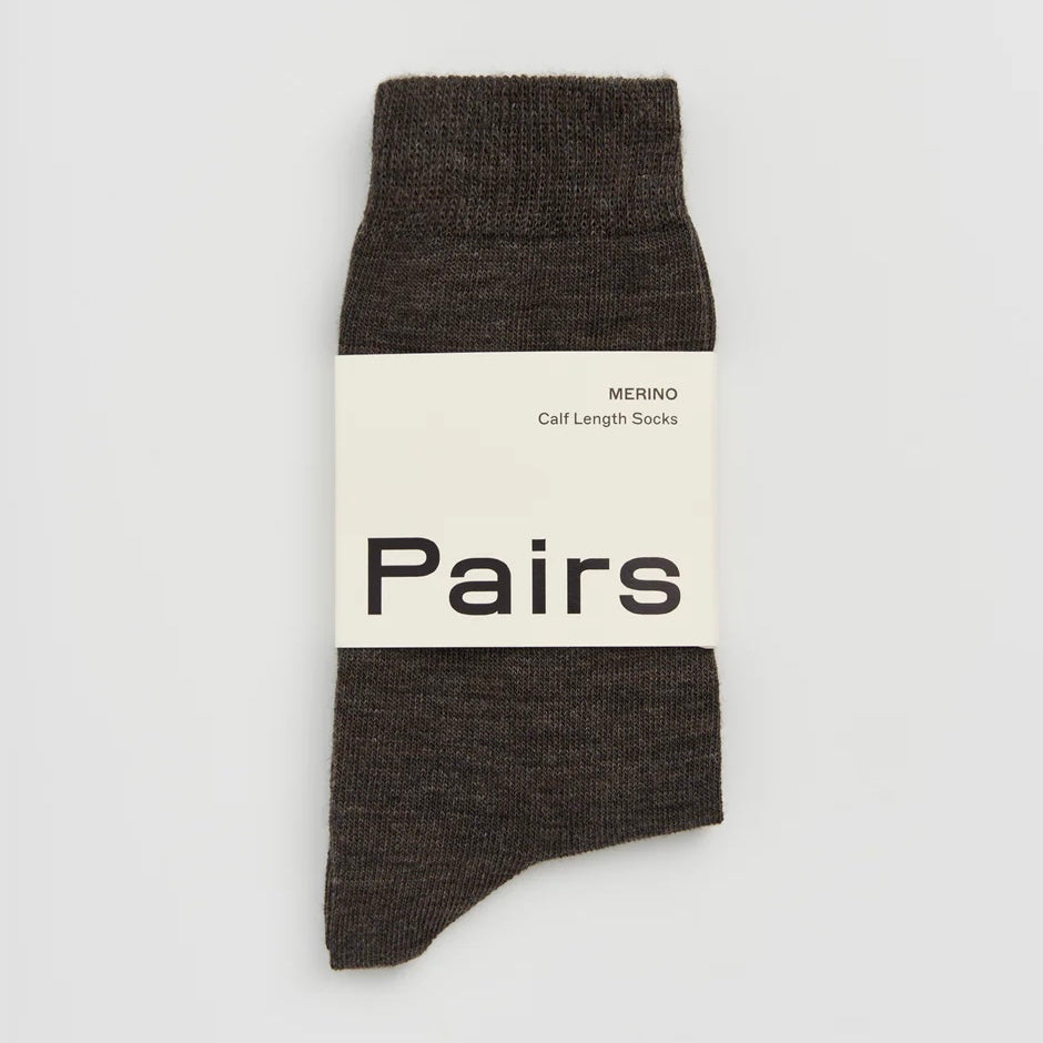 Dark brown merino wool sock with a 'Pairs' label on a light grey background