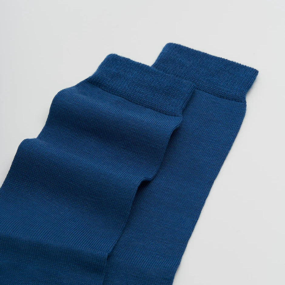 Pair of blue socks on a light grey background