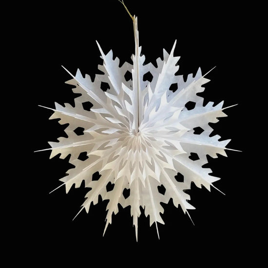 White paper snowflake decoration on a black background