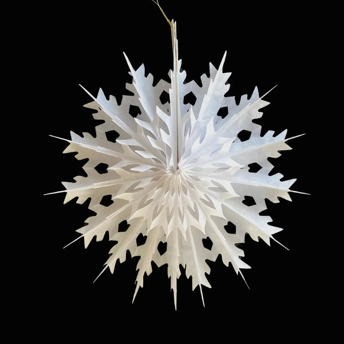 White paper snowflake decoration on a black background