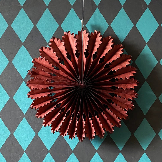 Chestnut paper fan decoration against a blue and gray checkered background