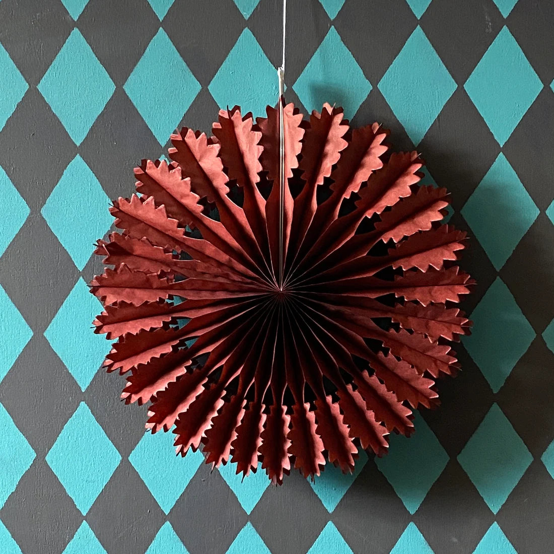Chestnut paper fan decoration against a blue and gray checkered background