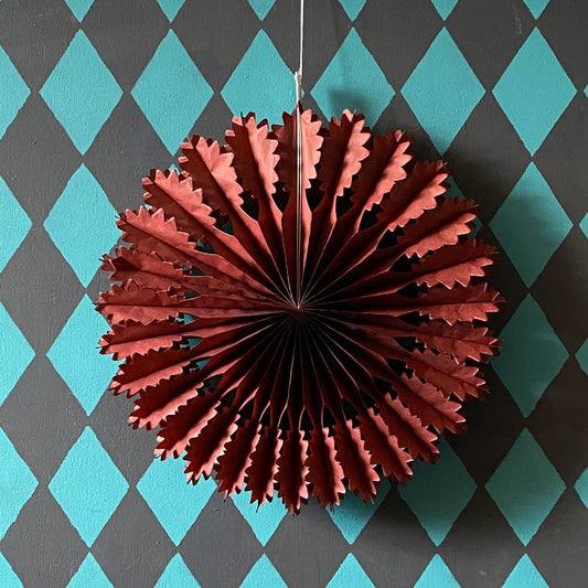 Chestnut paper fan decoration against a blue and gray checkered background