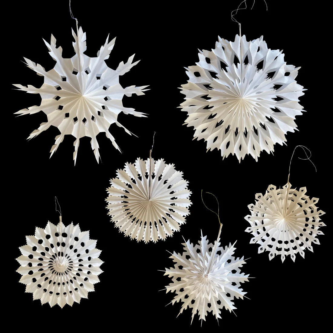 White paper snowflake decorations on a black background