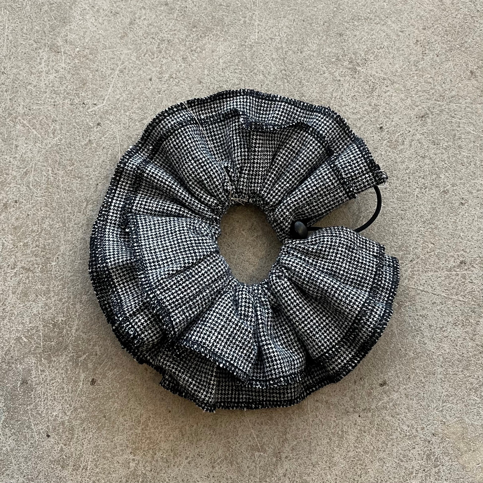Black and white checkered scrunchie on a beige surface