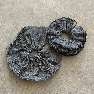 Two black and white checkered fabric drawstrings on a beige surface