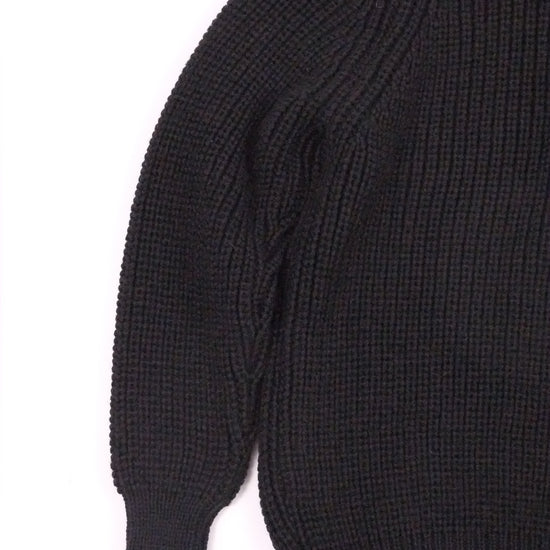 Close-up of a black sweater sleeve on a white background