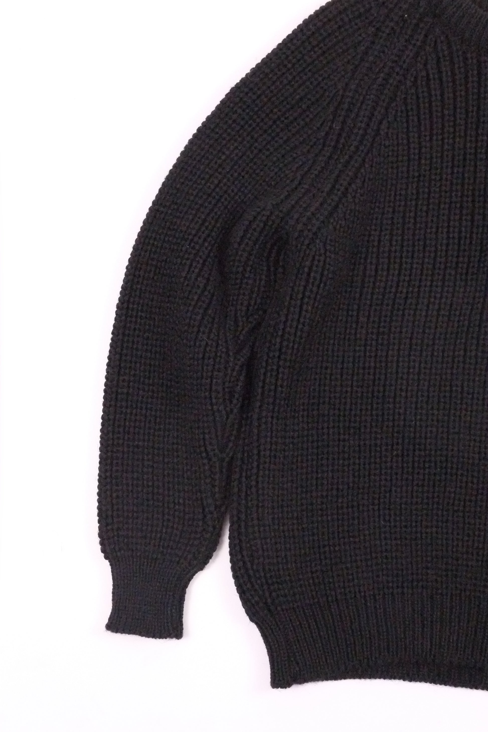 Close-up of a black sweater sleeve on a white background