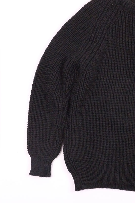 Close-up of a black sweater sleeve on a white background