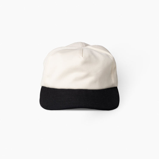 Two-tone cap with white top and black bottom on a white background