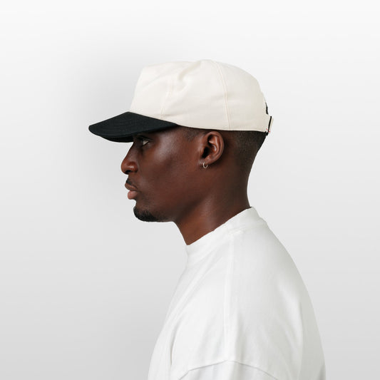 Man wearing a white cap and white shirt on a light gray background