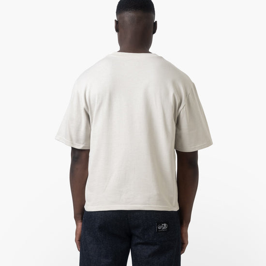A man facing backwards wearing a white tshirt on a white background 