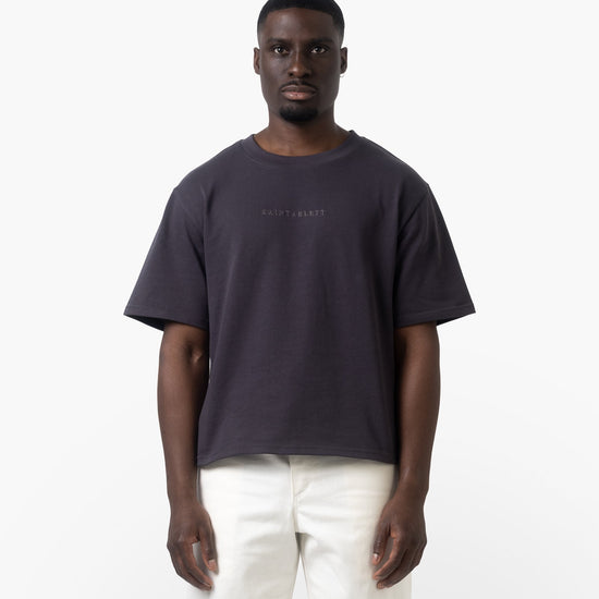 A man wearing a charcoal tshirt facing forwards