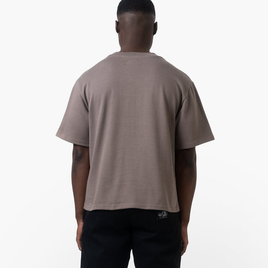 Man wearing a brown t-shirt with text on a white background