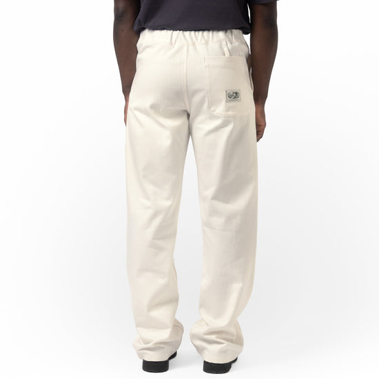 Person wearing white pants with a small logo on a white background