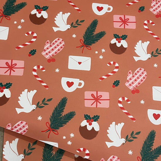 Christmas-themed wrapping paper with presents, candy canes, doves, and pine cones on a brown background.