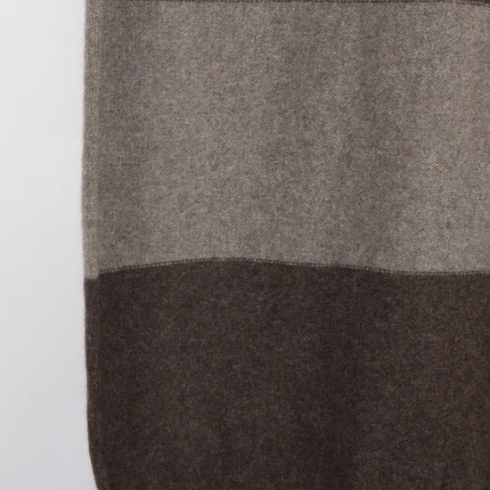 Close-up of a checkered scarf with brown and gray stripes on a white background