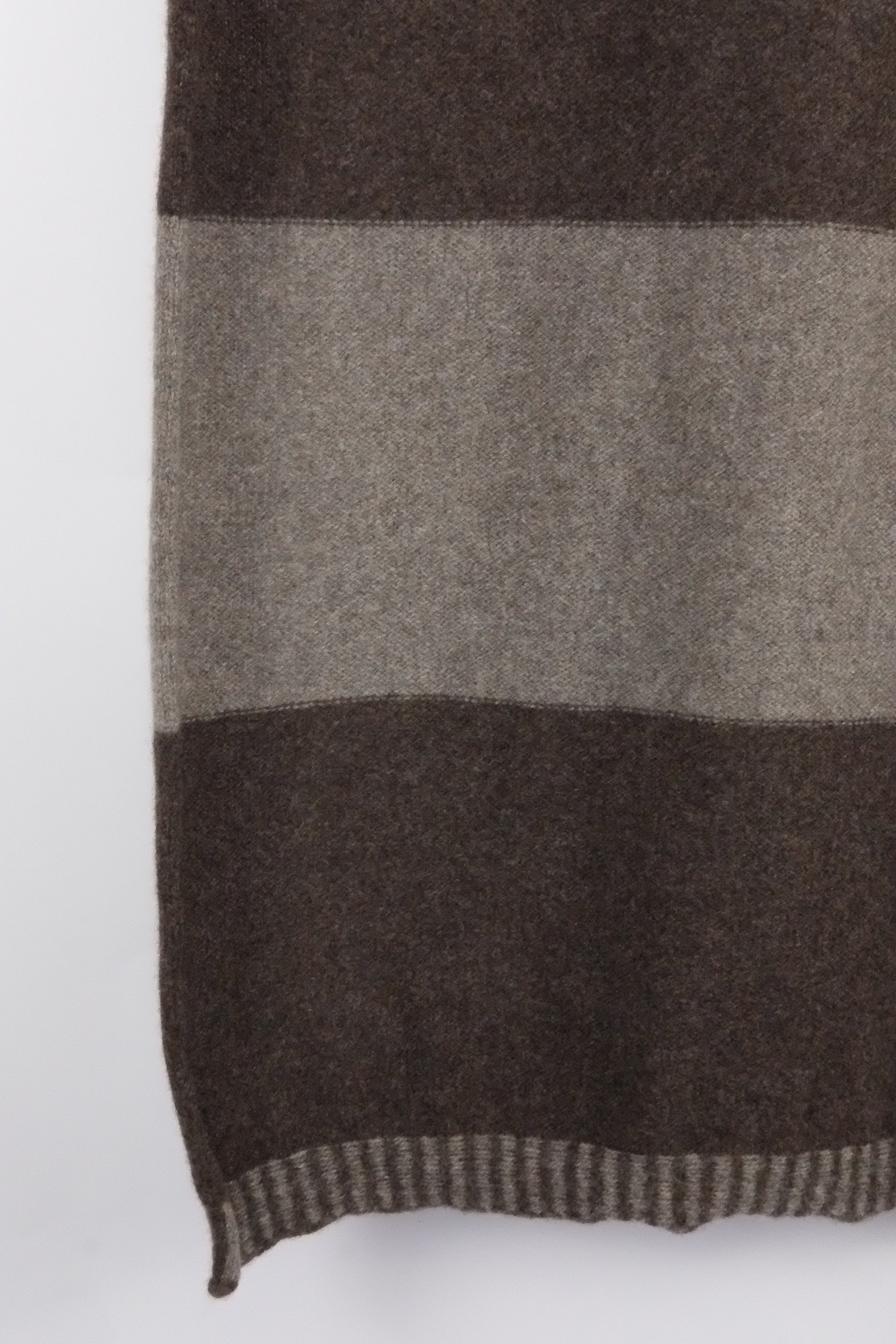 Close-up of a checkered scarf with brown and gray stripes on a white background