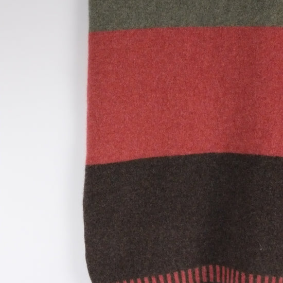 Textured fabric with green, red, and black stripes on a white background