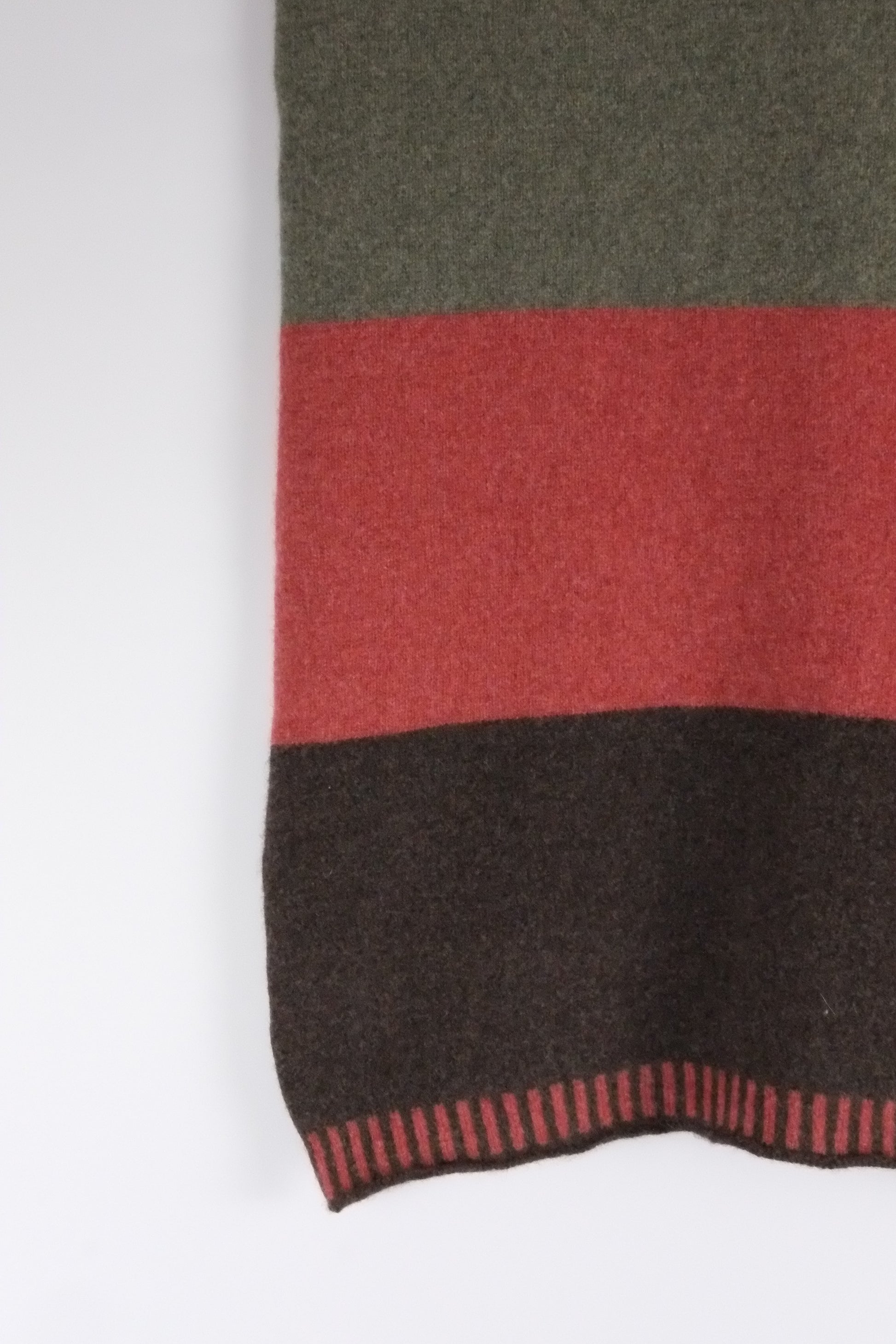 Textured fabric with green, red, and black stripes on a white background