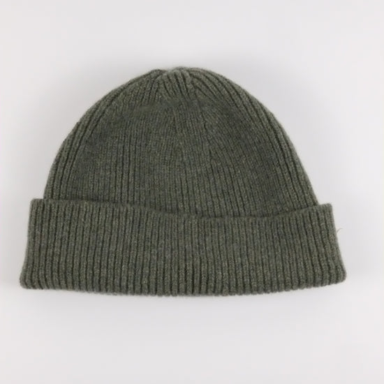 Green knit beanie on a white background