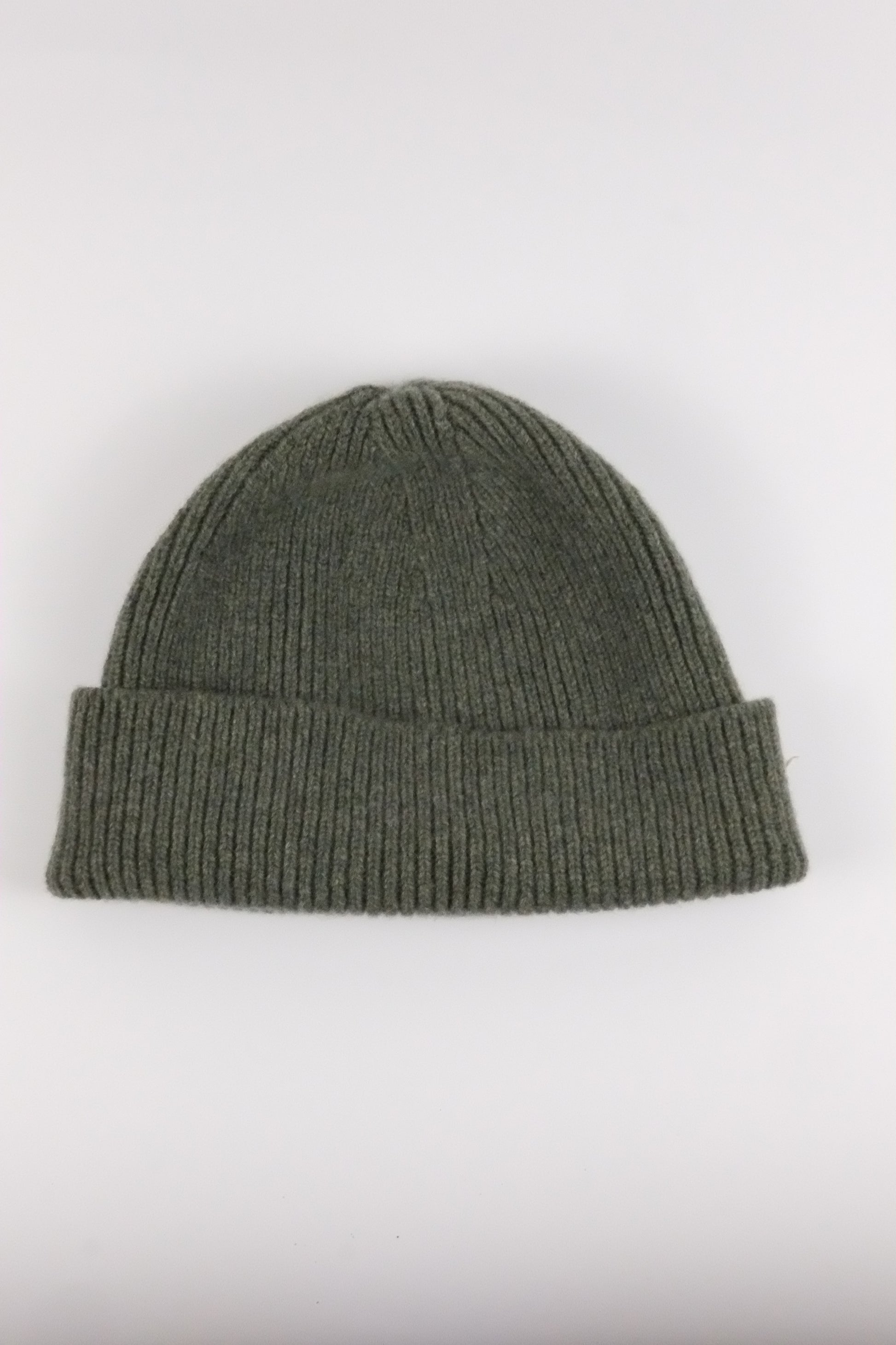 Green knit beanie on a white background