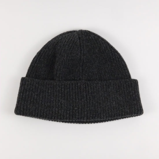 Black knit beanie on a light gray background